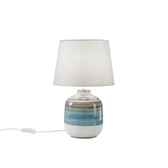 "Lume APACHE con base in ceramica e paralume in tessuto bianco."